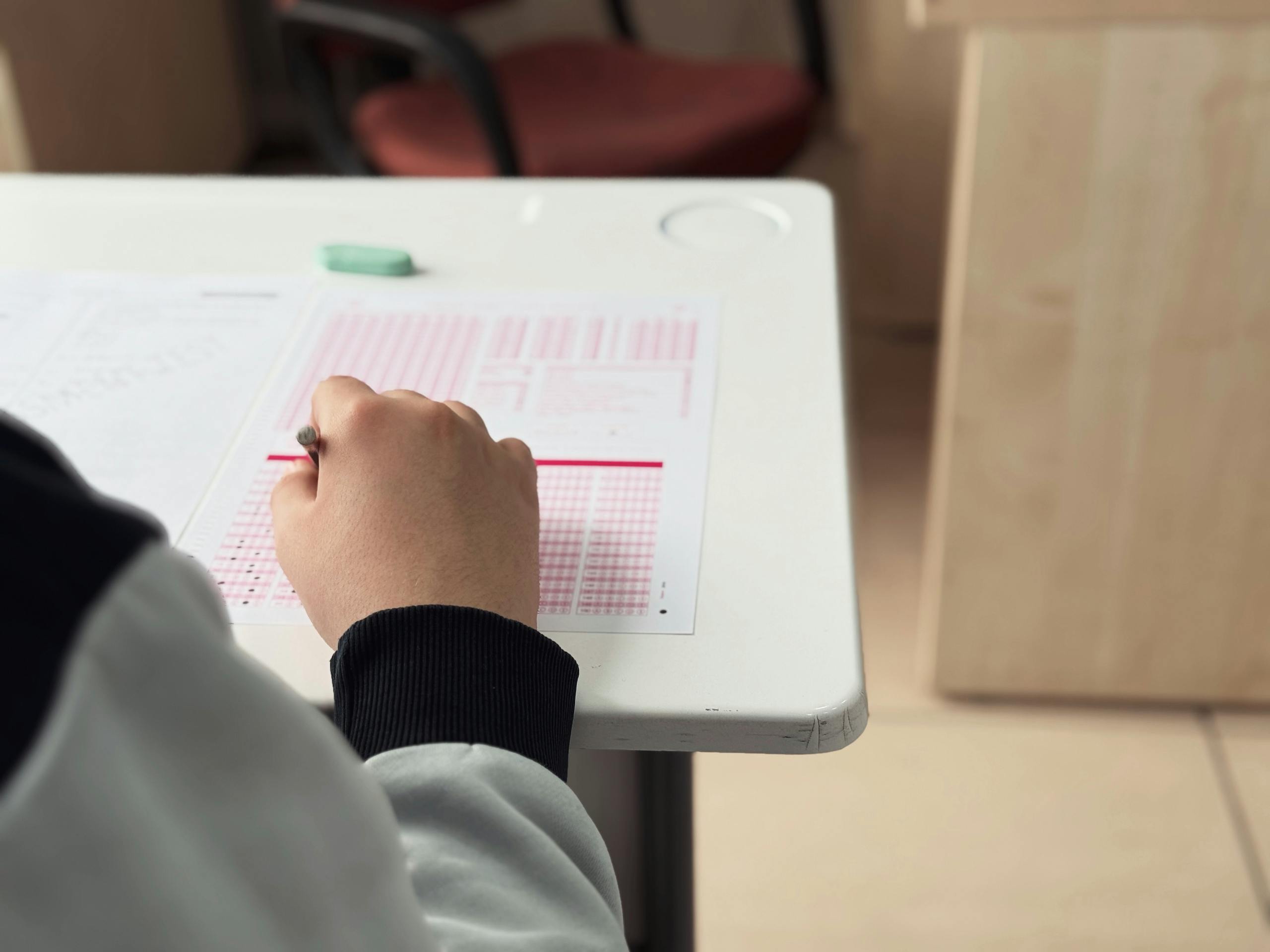 Close-up of student answering a test in a classroom environment.