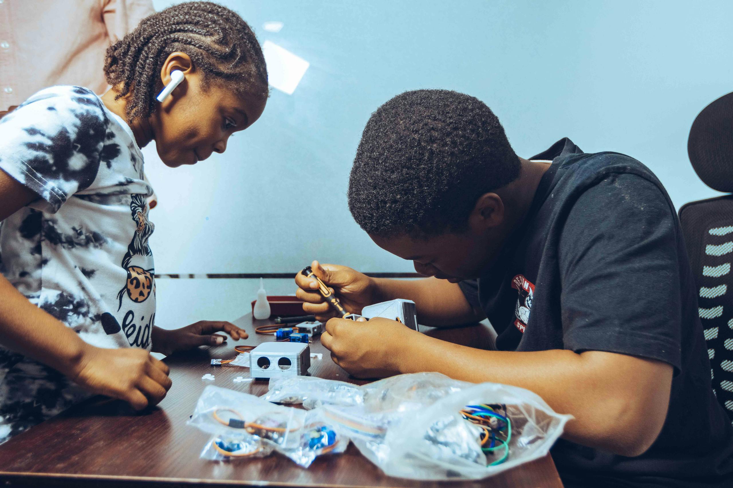 Two students engaged in hands-on electronics learning in a classroom setting in Accra, Ghana.